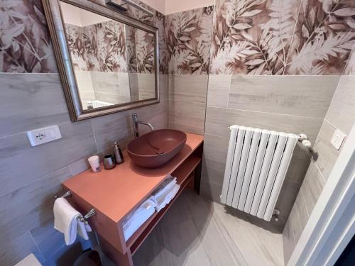 a bathroom with a sink and a mirror and a radiator at Cloe b&b di Angela Libertini in Penne