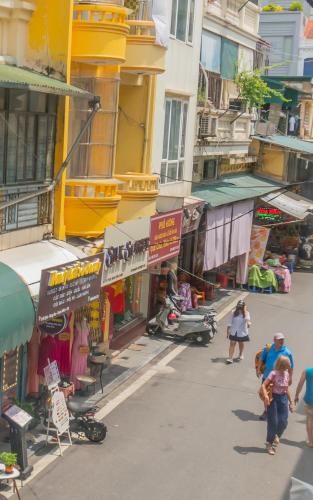 a group of people walking down a street with buildings at Sword Lake Hostel and Spa in Hanoi