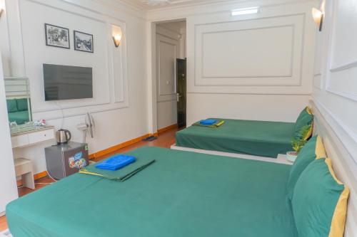a room with two beds and a television at Sword Lake Hostel and Spa in Hanoi