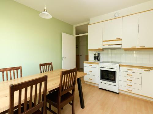 a kitchen with a wooden table and chairs at Spacious 3-Room Flat in Martinlaakso in Vantaa
