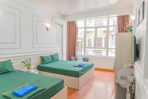 a hotel room with two beds and a window at Sword Lake Hostel and Spa in Hanoi