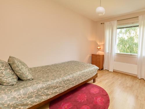 a bedroom with a bed and a window and a red rug at Spacious 3-Room Flat in Martinlaakso in Vantaa