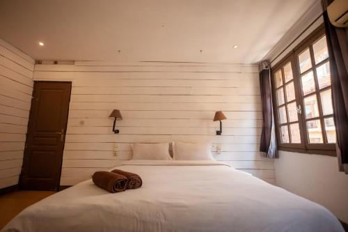 a bedroom with a bed with two towels on it at Hôtel Restaurant La Ribaudière in Antananarivo