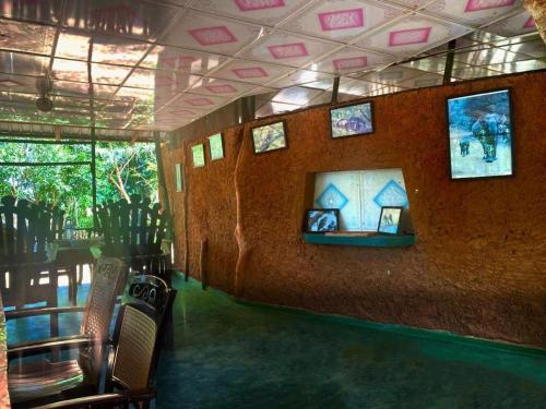 a room with a wall with pictures on it at Yala Wild Tree House in Hambantota