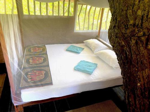 a bed in a tree with two pillows on it at Yala Wild Tree House in Hambantota