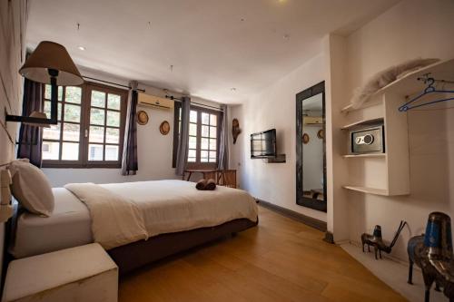 une chambre avec un grand lit et un miroir dans l'établissement Hôtel Restaurant La Ribaudière, à Antananarivo