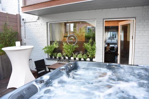 a jacuzzi tub sitting outside of a building at Suite 40 Jacuzzi & Sauna by Malmedreams in Malmedy
