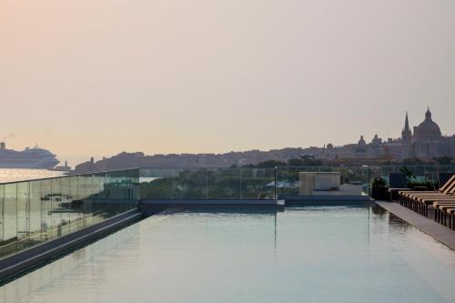 a swimming pool on the roof of a building at Novotel Malta Sliema in Il-Gżira
