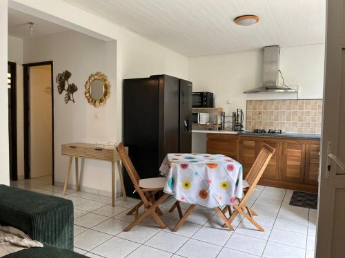 a kitchen with a table and chairs and a kitchen with a refrigerator at Azalée in Saint-Paul