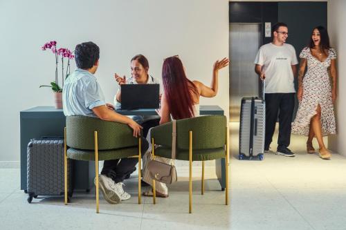 a group of people standing around a table with a laptop at Novotel Malta Sliema in Il-Gżira