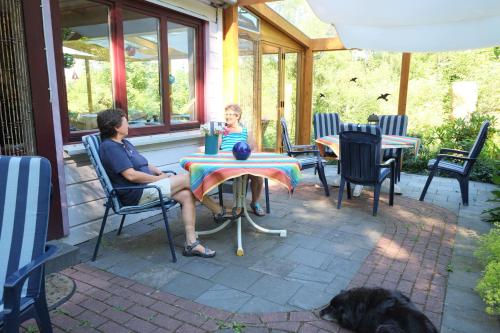 a man and a woman sitting at a table on a patio at Frauenpension Arleta - Women only in Goslar
