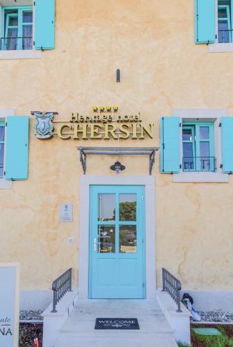 a building with a blue door and a sign above it at Heritage Hotel Chersin in Fažana