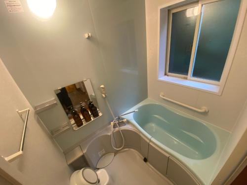 a bathroom with a bath tub and a toilet at Komore Villa Kita-Karuizawa こもれヴィラ北軽井沢 in Tsumagoi