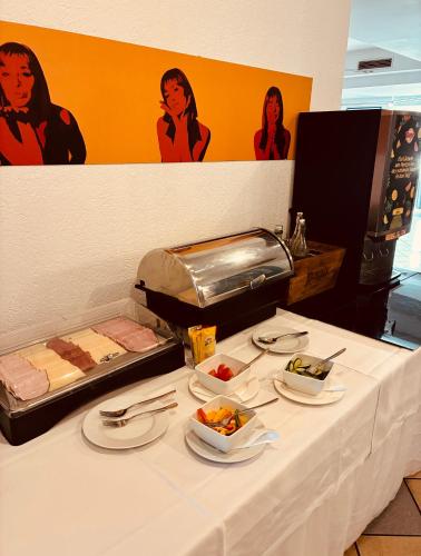 a white table with plates of food on it at Hotel Wirtshaus Römerhof in Leibnitz