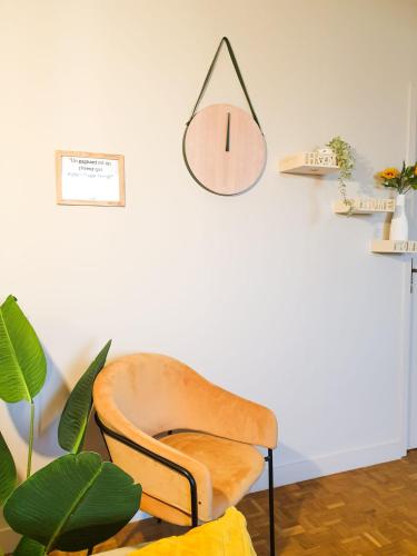a chair in a room with a clock on the wall at Cosy Myrtille Mûre - T5 - Grand appartement in Pau