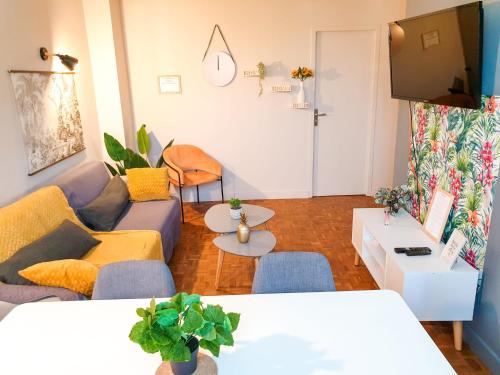 a living room with a couch and a tv at Cosy Myrtille Mûre - T5 - Grand appartement in Pau
