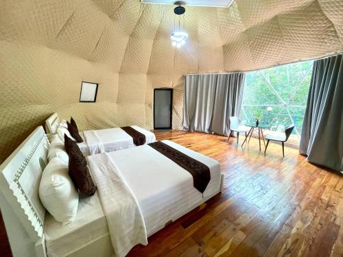 a bedroom with a large bed and a large window at Thisak Resort Cheung phnom kulen in Siem Reap