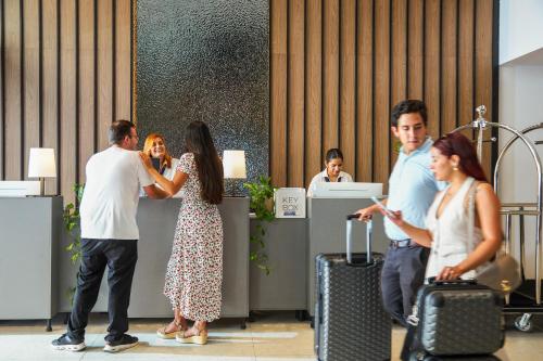 a group of people standing in an office with luggage at Novotel Malta Sliema in Il-Gżira