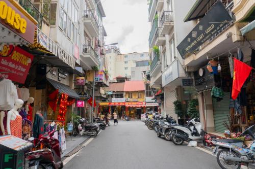 a city street with a bunch of shops and motorcycles at Sword Lake Hostel and Spa in Hanoi