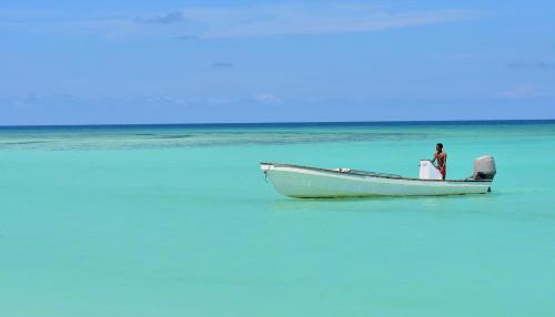 a man standing on a boat in the ocean at Hôtel de rêve Nosy Komba in Nosy Komba