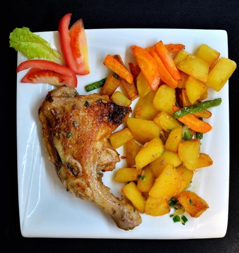 a plate of food with chicken and vegetables on it at Hôtel de rêve Nosy Komba in Nosy Komba