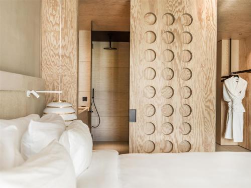 a bedroom with a white bed and a wooden wall at Radisson Collection The National Hotel, Brussels in Zaventem