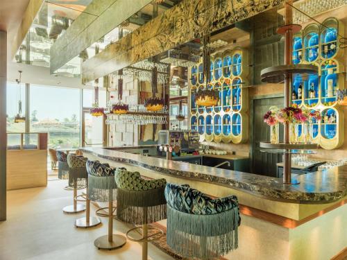 a bar with chairs and blue vases on the wall at Radisson Collection The National Hotel, Brussels in Zaventem