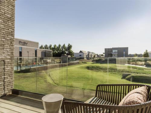 a balcony with a view of a golf course through a window at Radisson Collection The National Hotel, Brussels in Zaventem