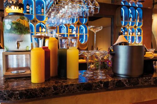 a bar with yellow bottles and glasses on a counter at Radisson Collection The National Hotel, Brussels in Zaventem