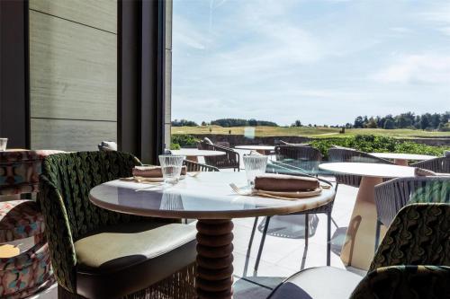 a restaurant with tables and chairs and a large window at Radisson Collection The National Hotel, Brussels in Zaventem