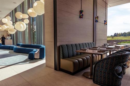 a restaurant with chairs and tables and chandeliers at Radisson Collection The National Hotel, Brussels in Zaventem