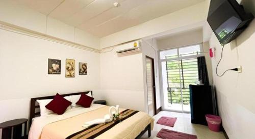 a bedroom with two beds and a flat screen tv at Rueangrat Hotel in Ranong