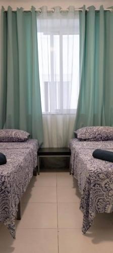 アリカンテにあるPensión La Marinaのベッド2台、窓(カーテン付)が備わる客室です。