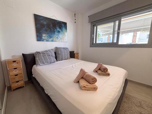 a bedroom with a bed with towels on it at Villa Amalia 25 Phase II in Torrevieja