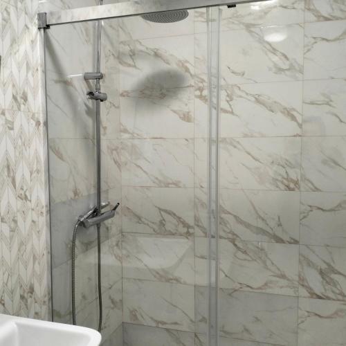 a shower with a glass door in a bathroom at Pensión La Marina in Alicante