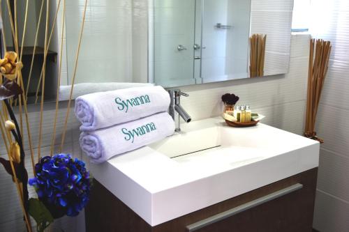 a bathroom with a sink with towels and a mirror at Hotel Syvanna Wellness and Spa in Pereira