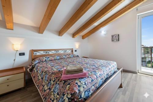 a bedroom with a bed and a large window at Ginevra in Toscolano Maderno