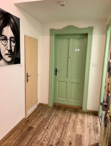 an empty room with a green door and a painting at Garsoniéra Ostrava City centr, Na Hradbách 118 in Ostrava