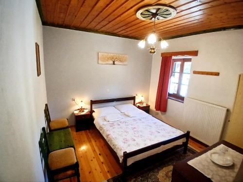 Un dormitorio con una cama y una mesa y sillas. en Aloni Guesthouse, en Ano Pedina