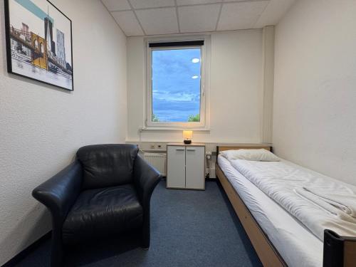 a hospital room with a bed and a chair at Thuja Apartments Karlsruhe-Neureut by KurzZeit in Karlsruhe