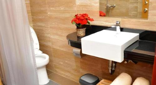 un bagno con un lavandino bianco e un water di MP Hotel Kelapa Gading a Giacarta
