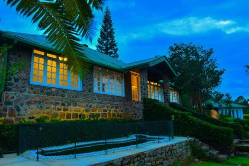 a stone house with a palm tree in front of it at The Bloomsdale Country House in Haputale