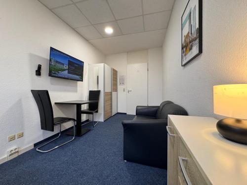 an office with a waiting room with a table and chairs at Thuja Apartments Karlsruhe-Neureut by KurzZeit in Karlsruhe