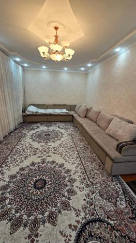 una sala de estar con un sofá y una alfombra en IVA guest House, en Karakol