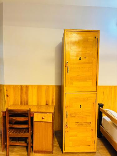 a bedroom with a desk and a wooden cabinet at Roamers Inn in Pokhara