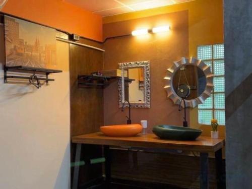 a bathroom with a sink and a mirror on a counter at Nora Bukit Hotel in Ban Sam Kong