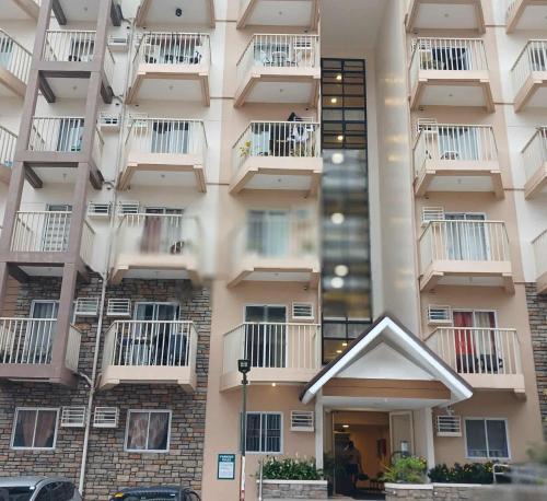 un edificio de apartamentos alto con balcones. en Cozy City Stay in Baguio, en Camp Seven