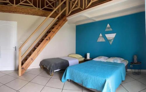 two beds in a room with blue walls at Maison cosy avec vue sur la montagne de Cilaos in Cilaos
