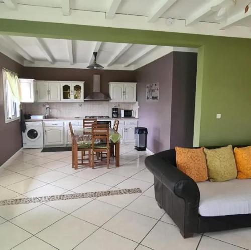 a living room with a couch and a kitchen at Maison cosy avec vue sur la montagne de Cilaos in Cilaos