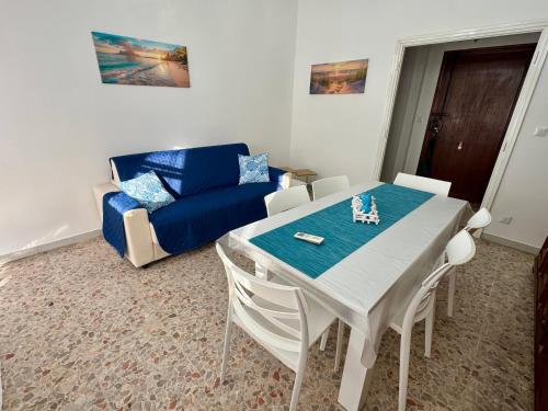 a living room with a table and a blue couch at La dimora di Traiano in Terracina
